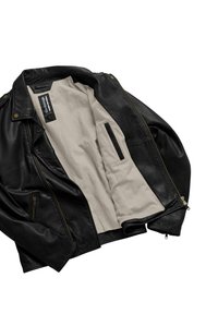 Giacca in pelle nera con chiusura a zip e colletto ampio. L'interno presenta una fodera color crema e una tasca laterale. Cuciture rinforzate visibili.