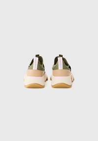 Grüne und beige Sportschuhe mit einem Mesh-Obermaterial, rosa und weißen Akzenten sowie einer gummierten Sohle mit einer strukturierten Oberfläche.