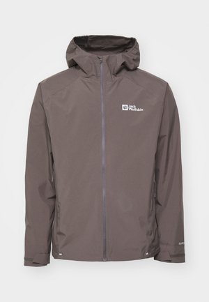 Giacca impermeabile marrone con cappuccio, chiusura con zip e tasche laterali. Presenta un tessuto testurizzato e un logo sull'area del petto sinistro.