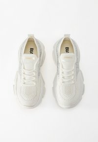 Weißer Sneaker mit einem strukturierten Mesh-Obermaterial, silbernen Akzenten und dicker Sohle. Verfügt über Schnürsenkel und Branding auf der Zunge.