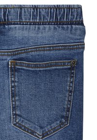 Jeans aus Denim mit blauer Waschung, ausgestattet mit einem elastischen Taillenbund und einer Gesäßtasche, die von kontrastierenden Nähten umrahmt wird.