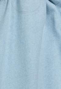 Lichtblauwe sweatshirt gemaakt van zachte stof, met een ronde halslijn en een voorzak. De textuur is iets gestructureerd en casual.