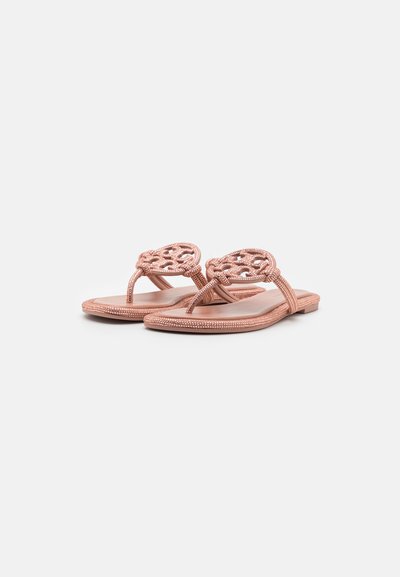 Rose gold flip-flopit, jossa on kudottu päällinen, tasainen pohja, sileä pinta ja koristeelliset helmimäiset yksityiskohdat remmeissä.
