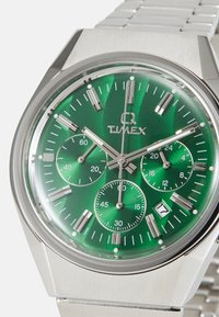 Silberner Edelstahlchronograph mit einem grünen strukturierten Zifferblatt, drei Unterzifferblättern, silbernen Akzenten und einer Datumsanzeige bei 4:00.