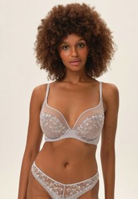 Szary koronkowy biustonosz i pasujące majtki z haftem w kwiaty, przezroczystymi panelami i regulowanymi ramiączkami. Gładka tekstura z metalicznymi akcentami.
