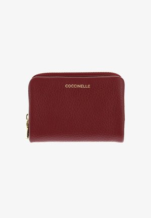 Portefeuille en cuir texturé bordeaux avec fermeture éclair dorée et nom de marque "COCCINELLE" embossé en or sur le devant.