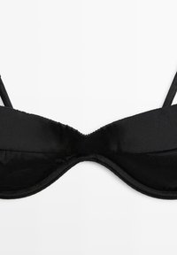 Soutien-gorge noir avec armatures, fines bretelles réglables et bonnets en tissu lisse sur fond blanc.