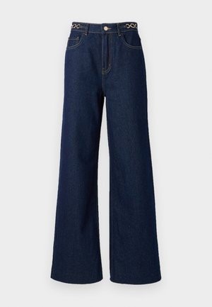 Jeans in denim blu scuro a gamba larga presentano una vita alta, dettagli in catena dorata in vita e cuciture a contrasto su tutta la loro lunghezza.
