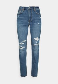 Högmidjade blå jeans i denim, med slitna områden och trasiga kanter, med en klassisk femficksdesign och metallbeslag.