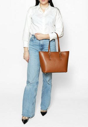 Brown faux leather tote bag with two top handles, structured design, and silver-tone hardware. Features a smooth texture and rectangular shape.