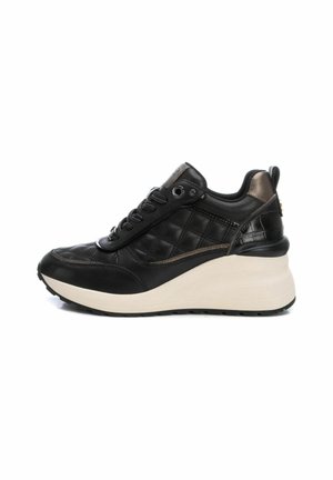 Zapatillas de cuero negro con un diseño acolchado y suela de plataforma beige. Incluye detalles texturizados y cordones negros.