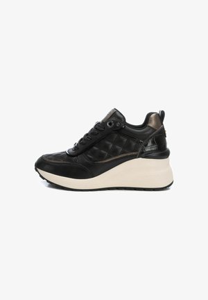 Zapatillas de cuero negro con un diseño acolchado y suela de plataforma beige. Incluye detalles texturizados y cordones negros.