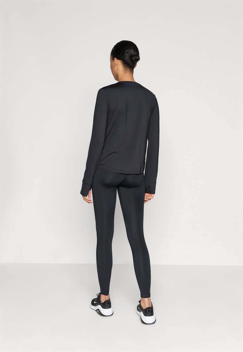 Zwarte lange mouw top gecombineerd met donkere legging. Heeft een zachte stof, een aansluitend ontwerp en een ronde hals. Vlakke naden zonder zichtbare patronen.