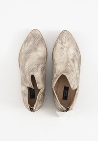 Botines de punta afilada en beige claro con un patrón de piel de reptil texturizada, que cuentan con una abertura lateral y un pequeño detalle de cremallera.