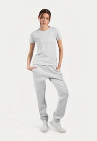 Grey cotton t-shirt with short sleeves and a crew neckline, paired with matching grey cotton sweatpants. Both garments feature a relaxed fit.