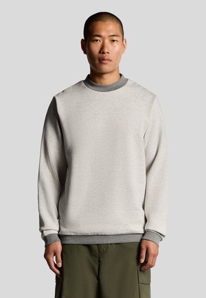 Lys grå sweatshirt med rund hals, grå accenter ved kraven og manchetterne, samt en blød tekstur, båret over olivengrønne bukser.