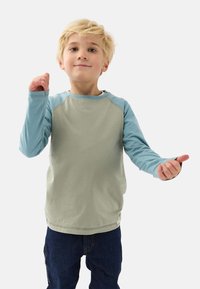 Langærmet skjorte med en lys grøn krop og blå ærmer, lavet af blødt stof, designet med rund hals og sidesømme.