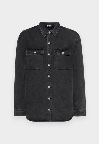 Zwarte denim shirt met een puntige kraag, sluiting met knopen aan de voorkant, twee borstzakken en zilveren hardware accenten. Lange mouwen met knoopmanchetten.