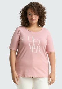 Roze katoenen t-shirt met korte mouwen, ronde halslijn en een witte grafische tekst met de tekst "BLOEM." Soepele textuur, casual pasvorm.