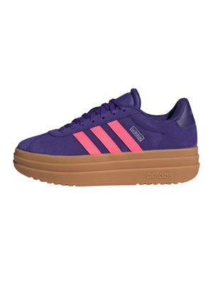 Fioletowy sneaker Adidas z różowymi paskami i grubą jasnobrązową podeszwą, widziany z boku na białym tle.