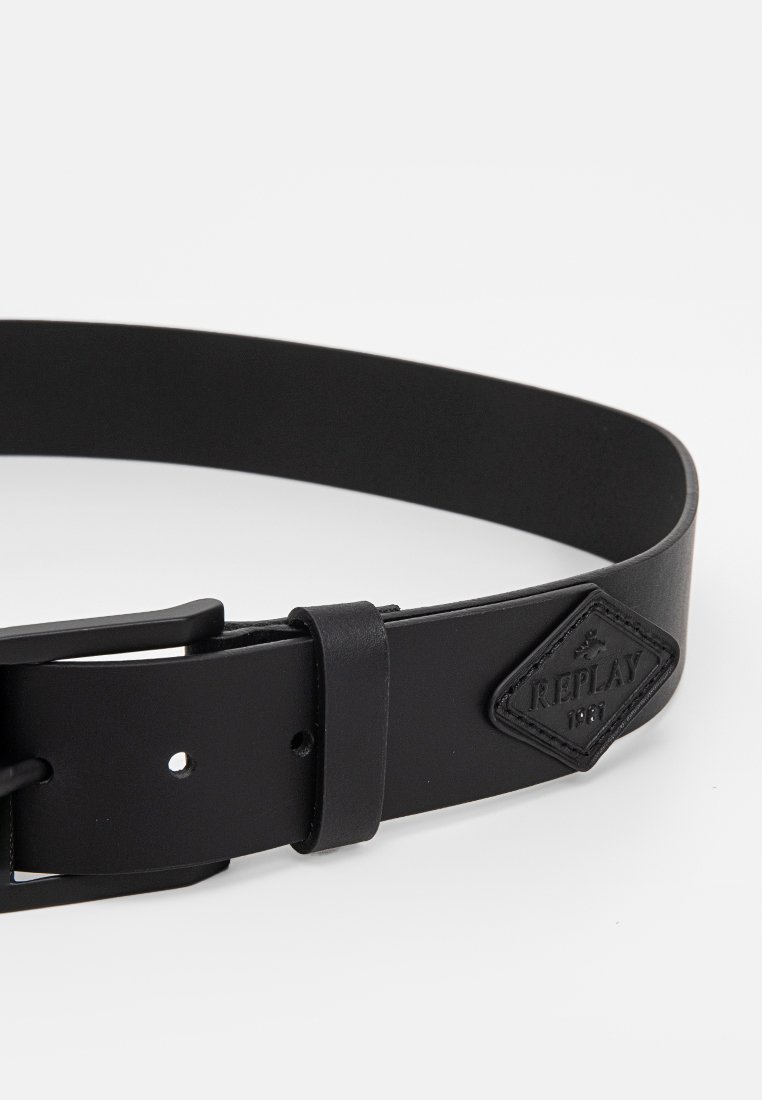 Ceinture en cuir noir avec une boucle rectangulaire, dotée d'une sangle ajustable et d'un patch en forme de diamant embossé avec "REPLAY 1981".