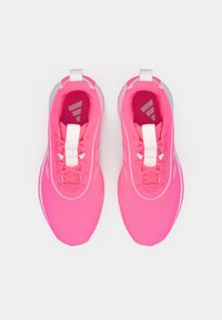 Scarpe sportive di un rosa acceso con tessuto a rete, lacci bianchi e suola strutturata. Dettagli bianchi sul tallone e sulla linguetta.