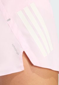 Pink athletic shirt featuring white three-stripe design, side slits, and "FORMOTION" text near the hem. Smooth texture, lightweight material.