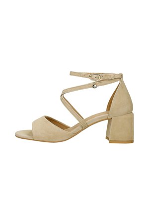 Sandale femme en daim beige avec talon bloc, bout ouvert et bride à la cheville avec petite boucle métallique et breloque.