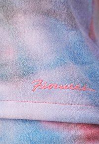 Lichtgewicht, gradient stof in roze en blauwe tinten; met geborduurd "Fiorucci" logo in roze aan de onderrand. Zachte textuur.