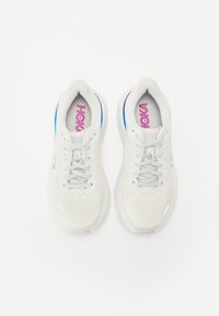 Baskets blanches avec dessus en maille, lacets gris et semelle colorée. Comprend un logo sur l'insole et un design de bout lisse et arrondi.