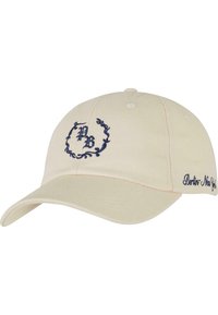 Kremfarget baseballcap med marineblå brodert logo, med buet skygge og dekorativ tekst på siden. Laget av bomull, med en strukturert form.