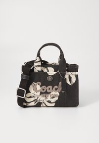 Borsa a tote nera con fiori bianchi, dotata di manico superiore, tracolla removibile, hardware in metallo e logo ricamato "Coach New York".