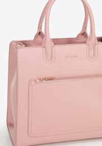 Różowa skórzana torebka na dwa uchwyty, z przednią kieszonką na zamek błyskawiczny z złotym suwakiem oraz nazwą marki "WITTCHEN" napisaną złotymi literami.