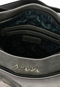 Borsa grigia con interno a patterned, tasca con zip nera e un'etichetta logo argento, dal design elegante e texture liscia.