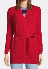 Röd virkad cardigan med en strukturerad mönster, öppen framsida, långa ärmar och ett matchande knytbälte i midjan. Ej bulkig design.