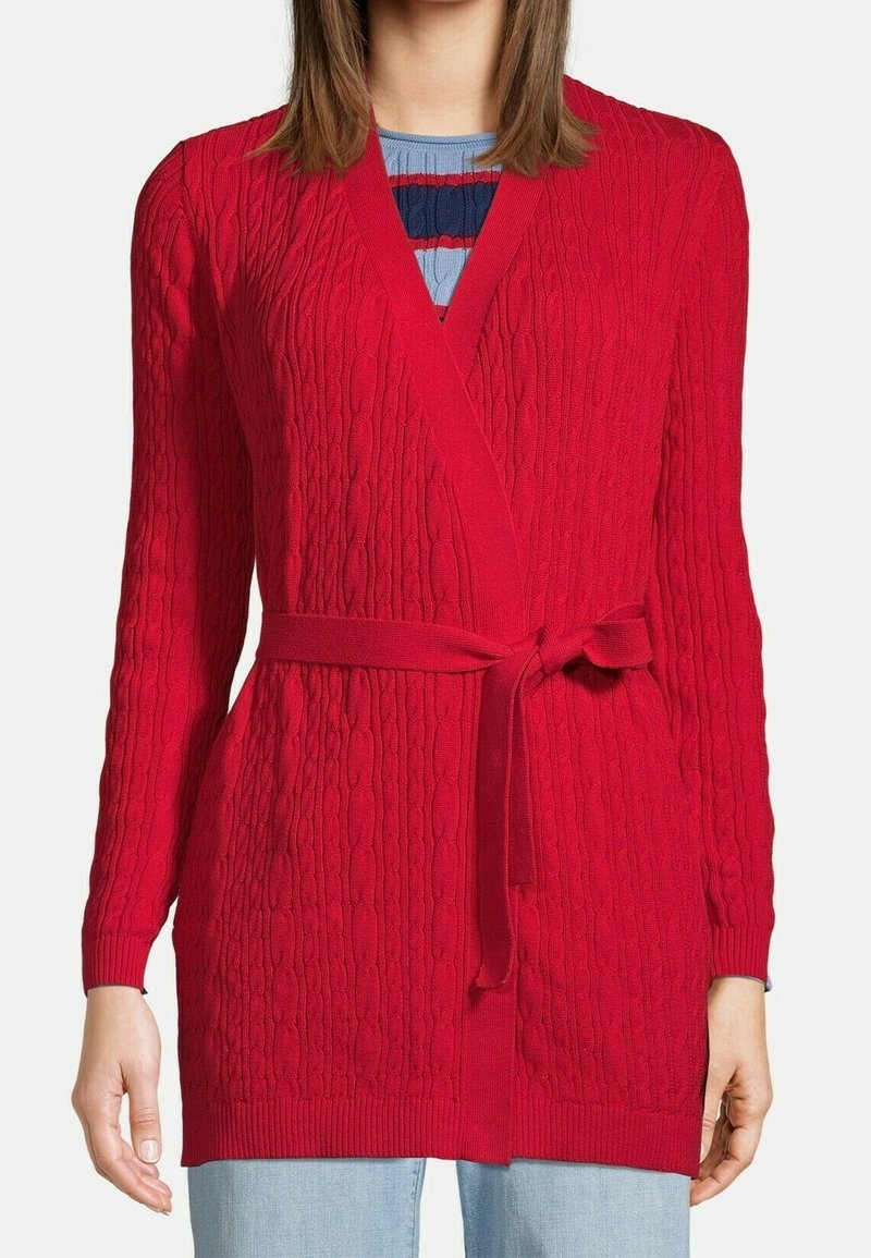Röd virkad cardigan med en strukturerad mönster, öppen framsida, långa ärmar och ett matchande knytbälte i midjan. Ej bulkig design.