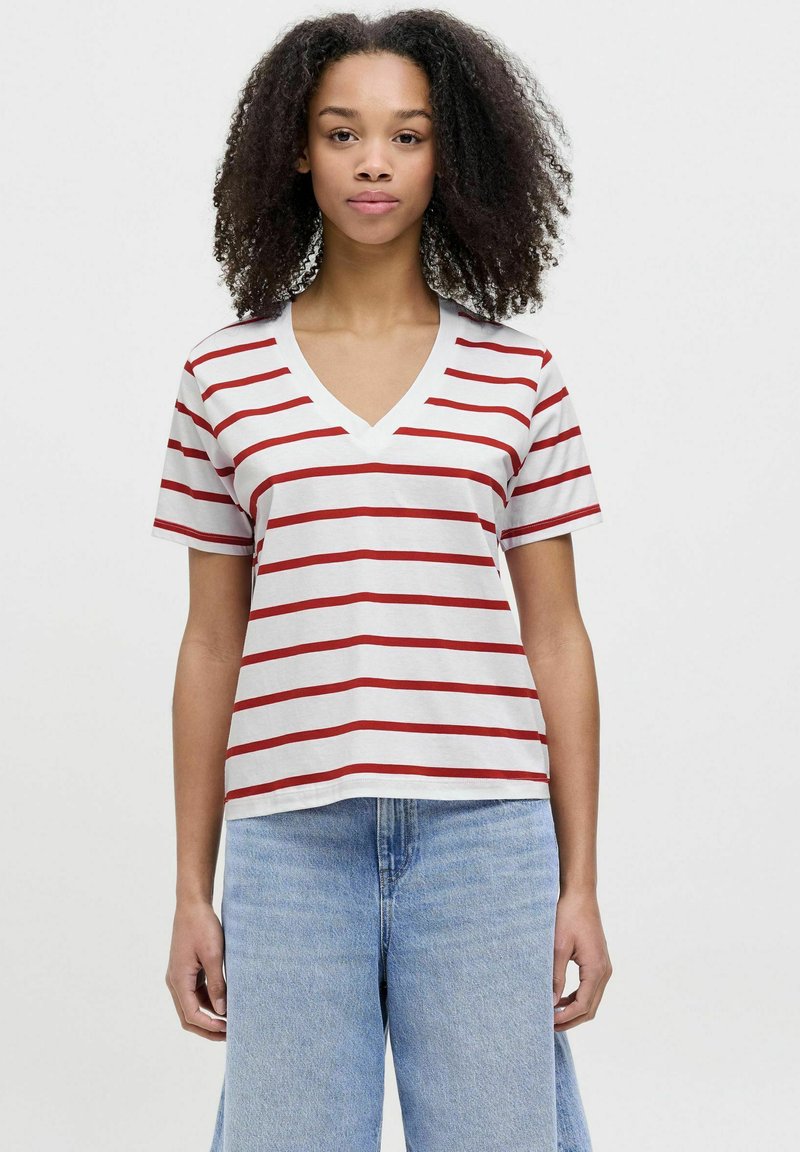 Camiseta de cuello en V de manga corta en blanco con rayas horizontales rojas. Fabricada con algodón suave, cuenta con un corte holgado y un dobladillo recto.