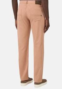Pantaloni rosa chiaro realizzati in tessuto morbido, con un design a gamba dritta, tasche posteriori e una toppa logo marrone sulla vita.