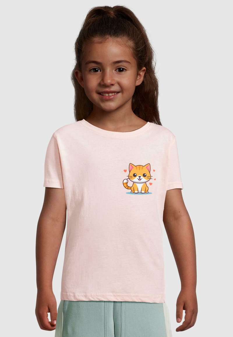 Lyserød t-shirt med korteærmer, der har en tegneserieagtig orange kat med en hvid mave, siddende på en blå overflade, omgivet af små lyserøde hjerter.