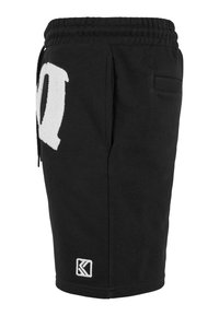 Black cotton shorts with an elastic waistband, featuring a side pocket, large white logo, and a textured fabric detail on the logo.