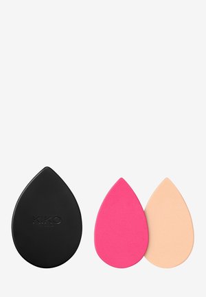 Etui pour éponges à maquillage en silicone noir avec une finition brillante. Deux éponges en forme de goutte, l'une rose et l'autre beige, avec une texture lisse.
