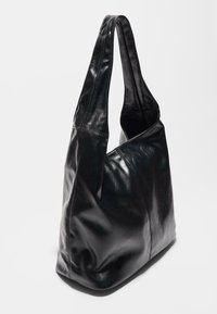 Borsa a spalla in pelle nera con un design morbido, dotata di una sola tracolla larga e dettagli di cucitura visibili. Texture liscia.