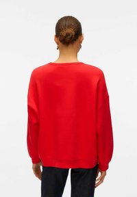 Roter, übergroßer Sweatshirt mit Rundhalsausschnitt, überschnittenen Schultern und gerippten Bündchen. Strukturiertem Stoff, einfachem Design und ohne Muster.