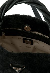 Borsa a tracolla di pelliccia nera con una tasca interna con zip e foderatura beige che presenta un motivo sottile. Accessorio con logo in metallo sulla parte anteriore.