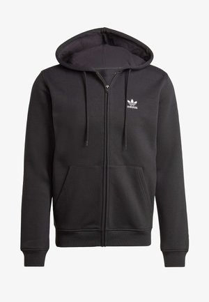 Sudadera con cremallera negra, fabricada en tela suave, con un bolsillo frontal, capucha con cordones y un pequeño logo blanco de Adidas en el lado izquierdo del pecho.