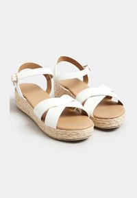 Sandali con zeppa in ecopelle bianca, con fasce incrociate, piattaforma in tessuto intrecciato naturale e cinturino alla caviglia regolabile. Sottopiede liscio di colore beige chiaro.