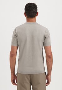 Lichtgrijs gebreid sweater met korte mouwen en ribbelstructuur op de mouwen en de zoom. Casual pasvorm met strakke lijnen en een ronde hals.