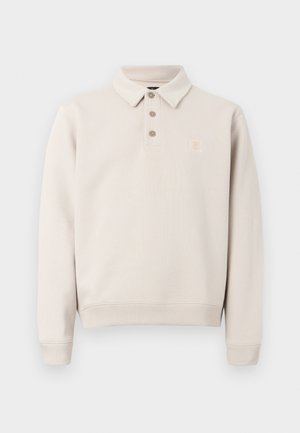 Polo beige à manches longues avec trois boutons, poignets et ourlet côtelés, et petite écusson logo sur la poitrine à gauche.
