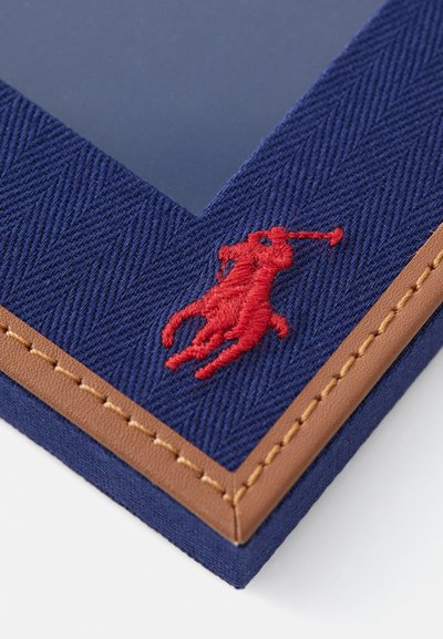Jūrų jūrlapių audinio nuotraukų rėmelis su rudu odos rėmeliu; turi raudoną išsiuvinėtą arklių logotipą. Kvadratinė forma, tekstūruotas paviršius.