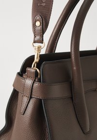 Borsa a mano in pelle marrone con superficie testurizzata, hardware dorato e tracolla a righe rimovibile. I dettagli includono cuciture decorative.